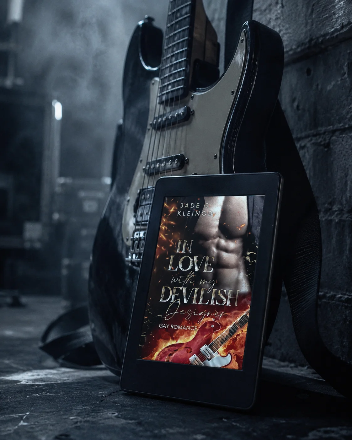 Kindle-Mockup des Covers von »In Love with my devilish Designer«, angelehnt an eine E-Gitarre in einer kühl blaugrauen Backstage-Umgebung.